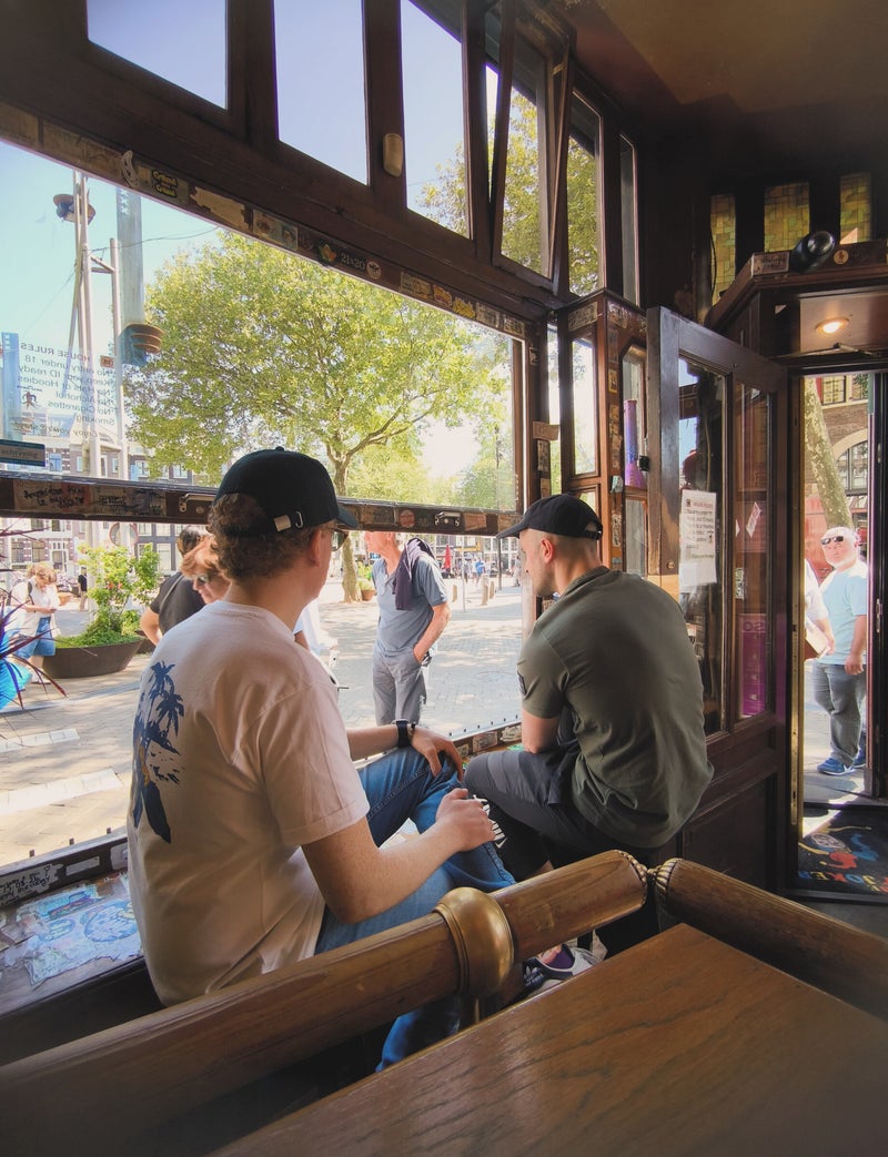 Visitors by the open window overlooking Nieuwmarkt